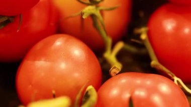 Marketteki olgun domateslerin yakın plan görüntüleri, canlı renkler ve sıcak ışık altında doğal dokular sergiliyor.