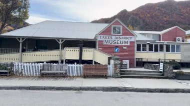 Sonbaharda Arrowtown, Yeni Zelanda 'daki Lakes Bölge Müzesi' nden bir araç geçer. Sahne canlı yeşillikleri ve tarihi mimariyi yakalıyor.