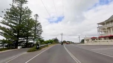 Büyük Okyanus Yolu boyunca 14 saniyelik sürüş, verimli yeşillikler, açık gökyüzü ve sakin bir atmosfer.