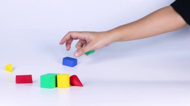 Yüzeyde renkli blokları düzenleyen eller