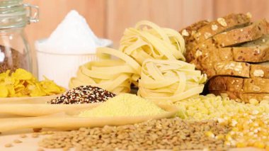 Tahta bir yüzeye dizilmiş tahıl, makarna ve ekmek çeşitleri.