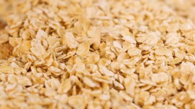 Yuvarlanan yulafların sıcak, doğal ışık ayarı, dokuyu ve hareketi vurgulayan ayrıntılı bir incelemesi