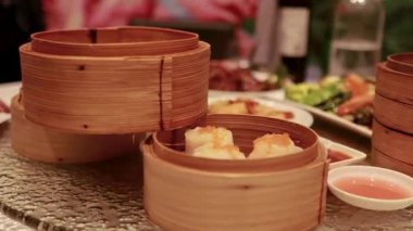 Döner masa, sıcak, davetkar bir restoran ortamında Dim Sum, Ördek ve çeşitli yemekleri gösterir.