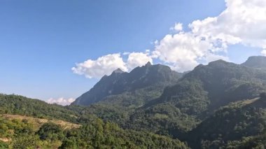 Berrak mavi gökyüzünün altında yemyeşil dağlar