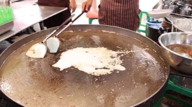 Man cooking pancake on giant pan, street food