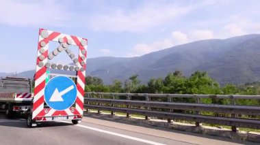 Workers setting up road signs on highway