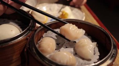 Person taking dumpling from a bowl