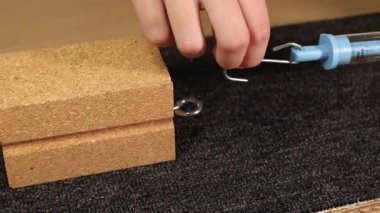 Bir el, halının üzerindeki tahta bloğun sürtünme kuvvetini ölçmek için yay ölçeği kullanır.