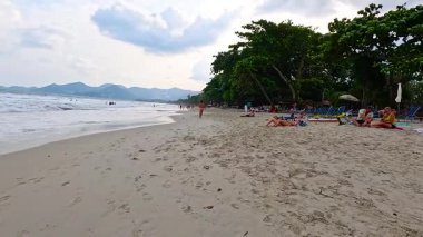 İnsanlar Tayland 'da güneşli bir plajın keyfini çıkarıyorlar.