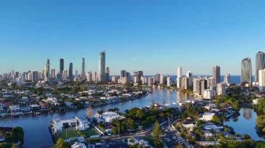Drone, Gold Coast 'un ufuk çizgisinin ve su yollarının dinamik hava görüntülerini canlı günbatımı ışıkları altında yakalıyor, kentsel ve doğal güzellikleri gözler önüne seriyor.