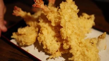 Servis tabağında tempura düzenleyen eller