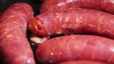 Tavada pişen sosis ve mantarlar.