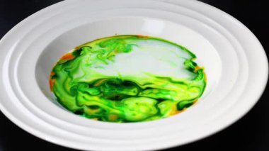 Sütte canlı renkler dolaşır ve desenler yaratır.