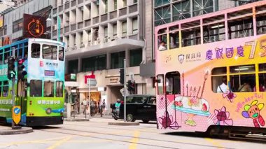 Canlı tramvaylar hareketli Hong Kong caddelerinde geziniyor.