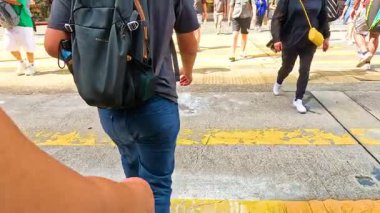 Kalabalık bir şehir kavşağında yürüyen insanlar