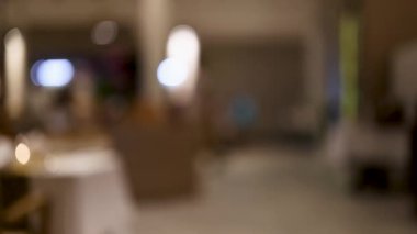 Gece hareketli bir Tayland restoranının bulanık görüntüsü, rahat bir ortamda ortam ışıklarını ve hareketlerini yakalıyor.