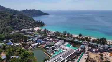 Phuket 'in sahil şeridinin hava görüntüleri. Lüks tatil beldeleri, canlı yeşillikler ve berrak gökyüzünün altındaki turkuaz sular.