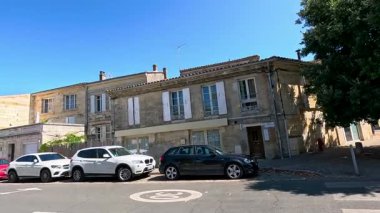 Ağaçlık bir cadde boyunca park etmiş arabalar.