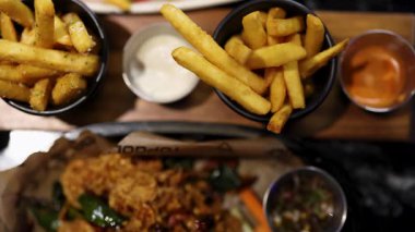 Golf sahasında soslara patates kızartması karıştırmak.