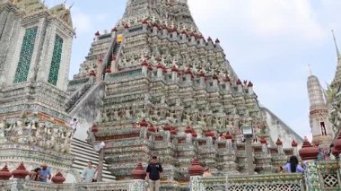 13 saniyelik bir video, Wat Arun 'un karmaşık mimarisini Bangkok, Tayland' da açık mavi bir gökyüzüne yansıtıyor.