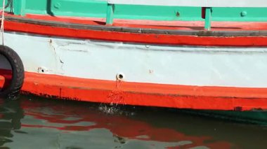 A side view of a boat floating on calm water
