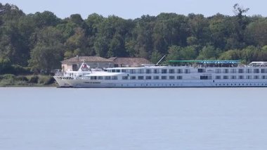 A cruise ship sails along a river