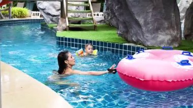 Çocuklar şişme yüzükle yüzmeyi severler.