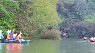 İnsanlar yemyeşil manzarada kürek çekiyorlar.