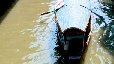 Bangkok, Tayland 'da bir tekne, doğal ışıklandırma altında geleneksel kürek çekme tekniklerini sergiliyor.