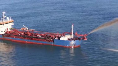 Avustralya 'nın Gold Coast yakınlarındaki okyanusa kum püskürten bir tarayıcının hava görüntüsü.