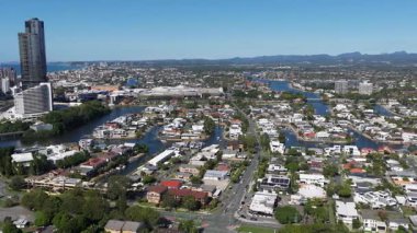 İnsansız hava aracı görüntüleri, nehirleri, binaları ve uzak dağları olan kıyı şehrinin güneşli ve geniş bir görüntüsünü yakalar.