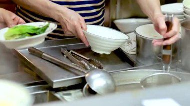 Şef erişte çorbasını taze malzemelerle hazırlıyor.