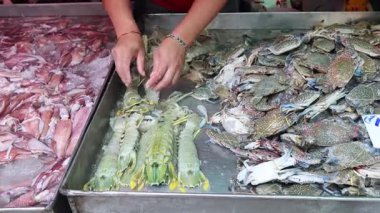 Pazarda balık ve kabukluları ayıran eller