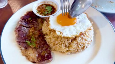 Biftek ve pirinç dilimlenmiş yumurta sarısı.