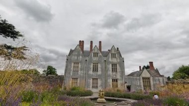 Parlak, renkli bahçelerle çevrili görkemli bir ev.