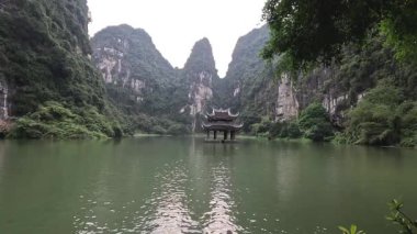 Tekne, yüksek kireçtaşı kayalıkları arasında nehirde süzülüyor.