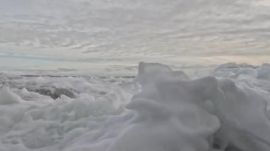 Dalgalar sahile çarpıyor ve su sıçrıyor.