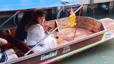 Turistler kayıkla yüzen pazarı keşfediyorlar