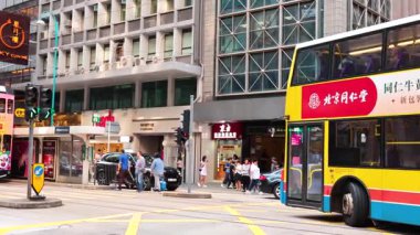 Şehir caddesinde çift katlı otobüs ve yayalar.