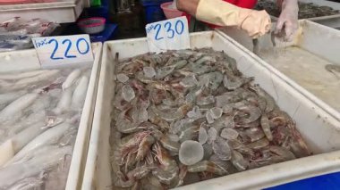 Deniz ürünleri pazarında karides ve balığı ayıran eller.