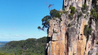 Açık mavi gökyüzünün altında görkemli Nimbin Kayaları 'nı gösteren hava görüntüleri doğal güzellikleri ve engebeli manzaraları vurguluyor.