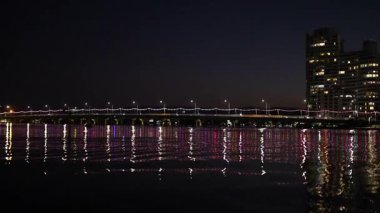 Aydınlatılmış köprü sakin suyu yansıtıyor