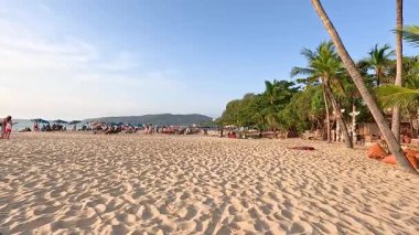İnsanlar Phuket, Tayland 'da güneşli plaj günlerinin tadını çıkarıyorlar.