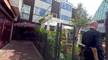 Person walking through a garden cafe area