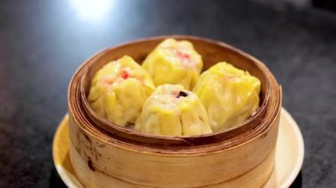 Bambu buharlı bir sepetteki Dim sum köfteleri.