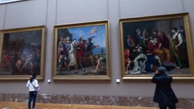 Visitors admire paintings in the Louvre Museum