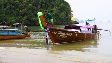 Man balancing on boat in Krabi, Thailand
