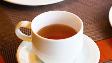 A hand lifts a tea cup