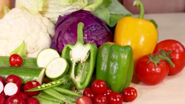 Ahşap bir yüzeyde çeşitli renkler ve dokular sergilenen canlı bir sebze çeşidi.