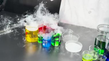 Chemist conducts experiment with colorful liquids and smoke